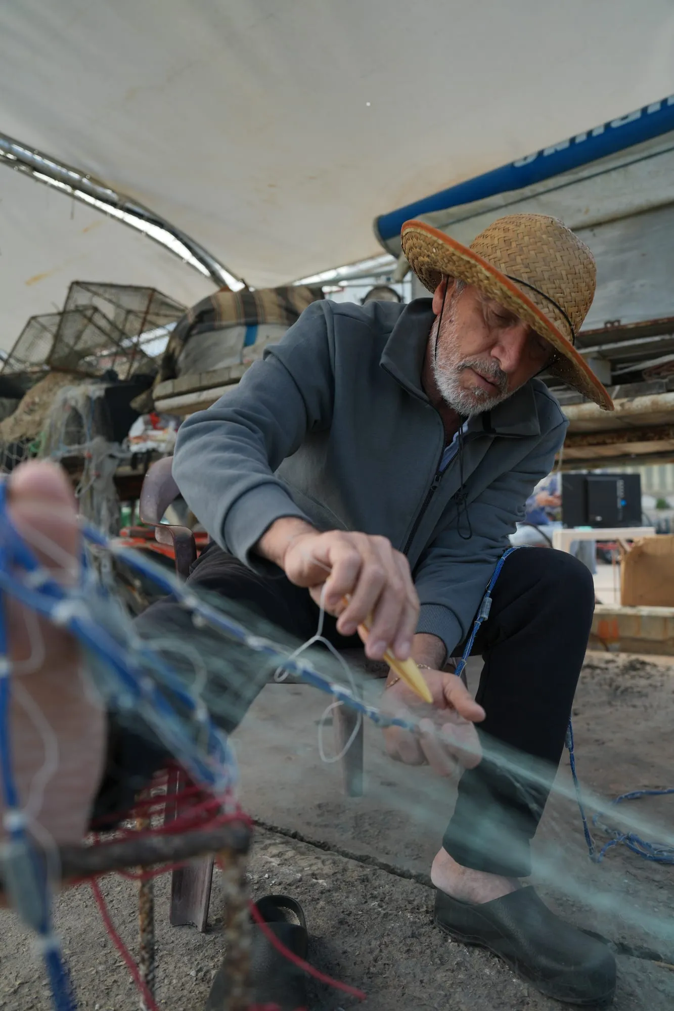 Assal, the father of the Oyster's Seafood Bar family, mending a fishing net by hand at Batroun Mina