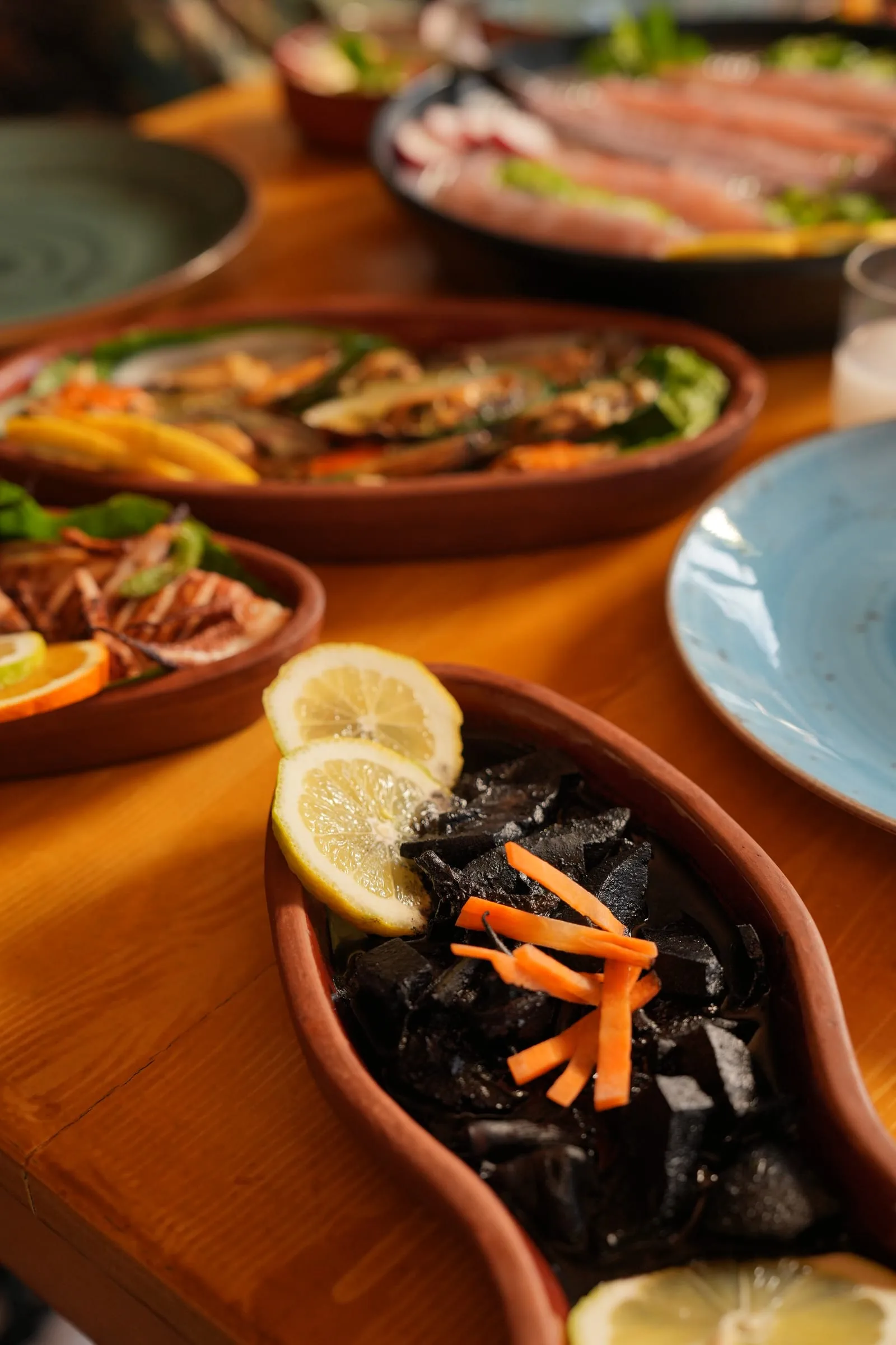 Calamari in its ink with lemon in a terracotta dish at Oyster's Seafood Bar, Batroun