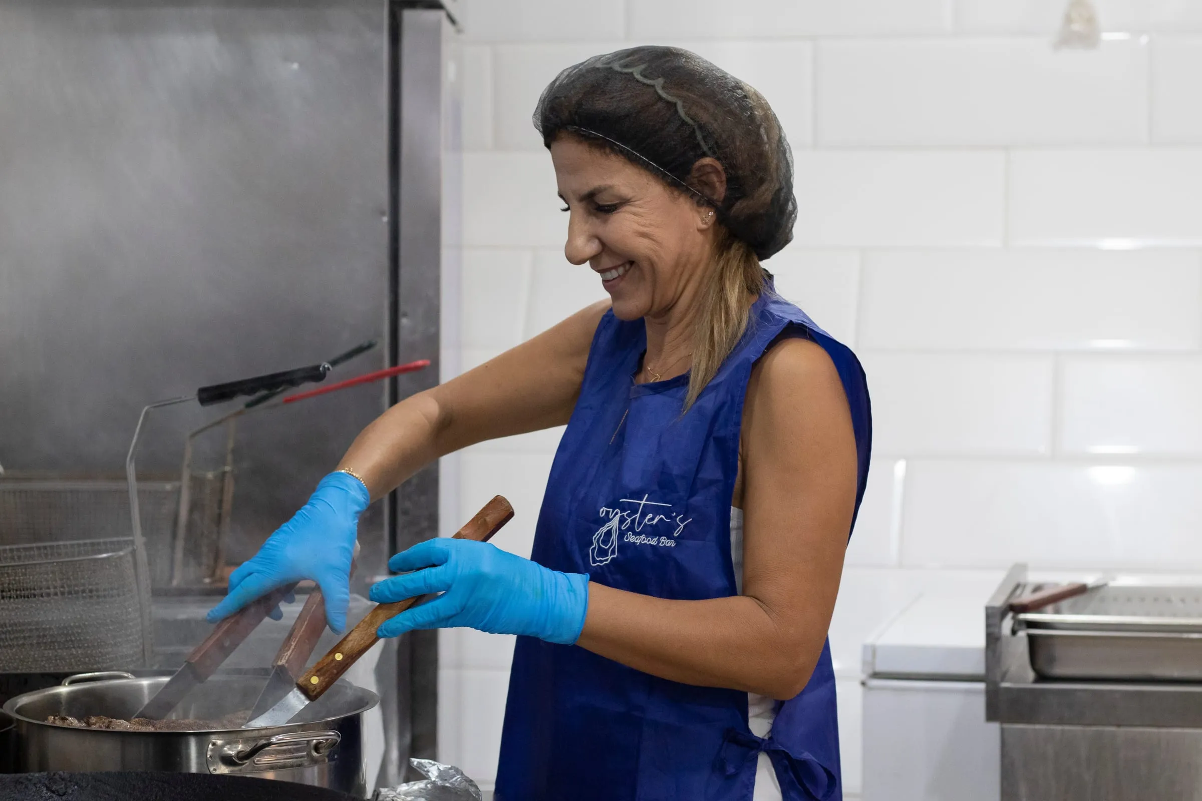Marcelle, our mother, cooking at the stove in the kitchen of Oyster's Seafood Bar, Batroun Mina