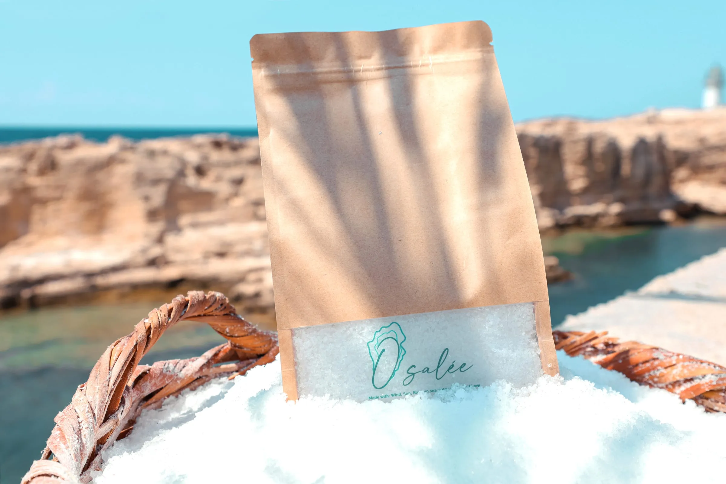 An Osalée sea salt pouch standing in a basket of salt by the sea in Batroun
