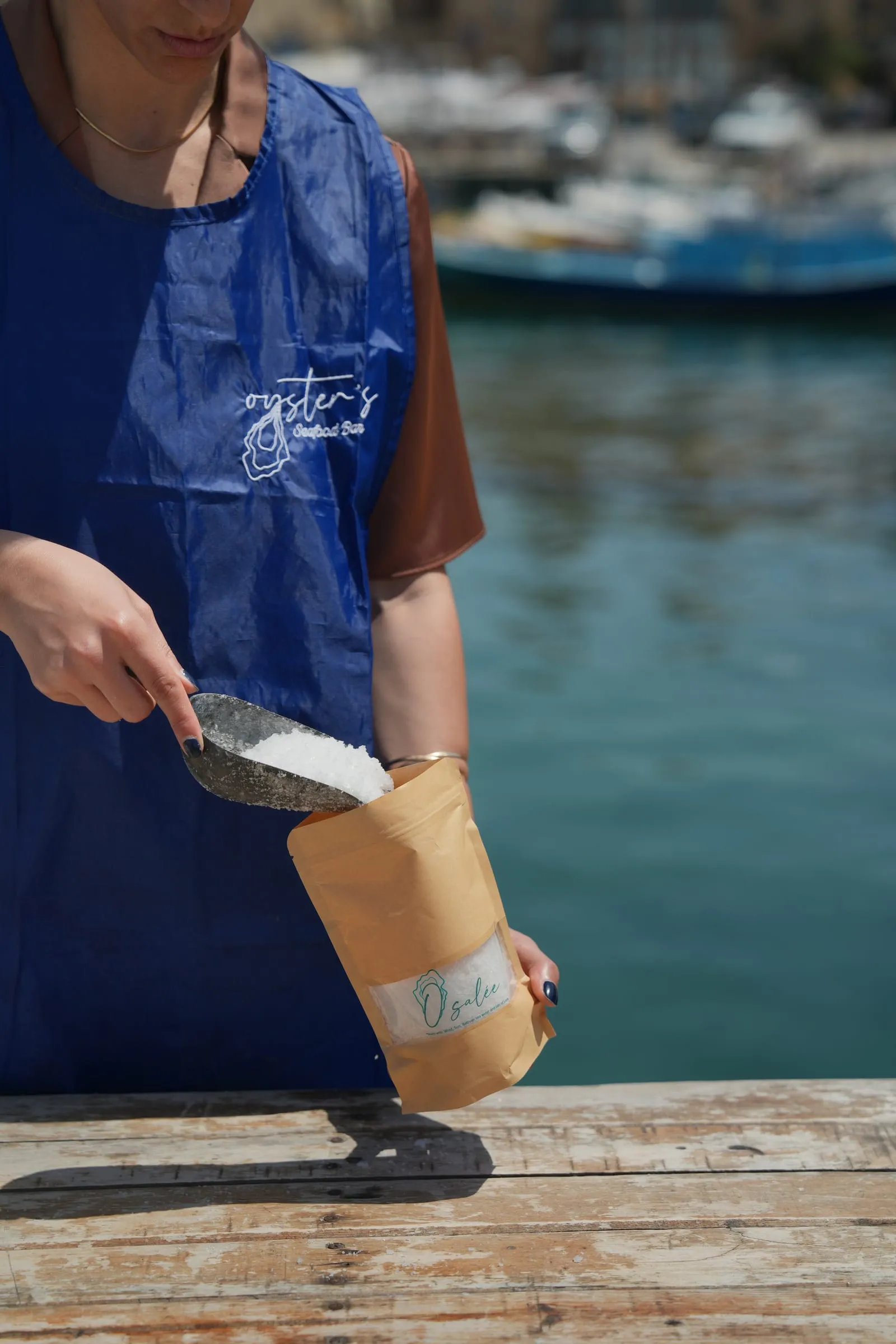 Sea salt being scooped into an Osalée pouch at Batroun Mina, in the Oyster's apron