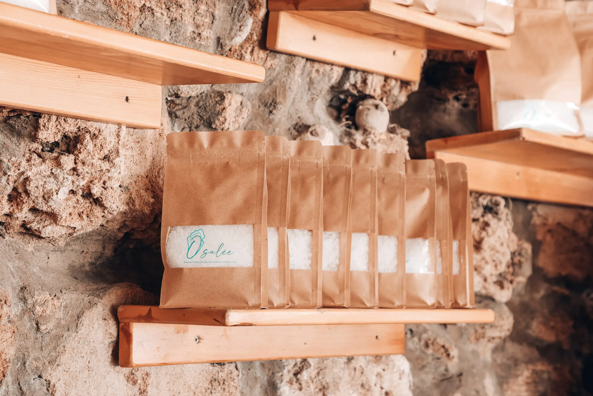 A row of Osalée sea salt pouches on a wooden shelf at Oyster's Seafood Bar, Batroun