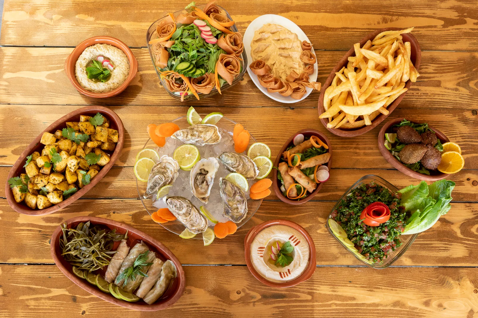 A platter of oysters on ice in the middle of a table of mezze at Oyster's Seafood Bar, Batroun