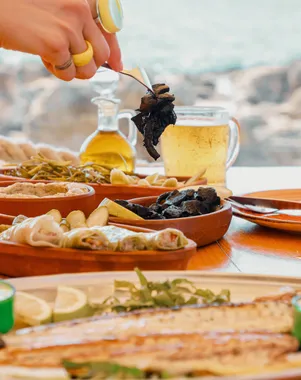 A drink being poured from a jug over a table of seafood at Oyster's Seafood Bar, Batroun