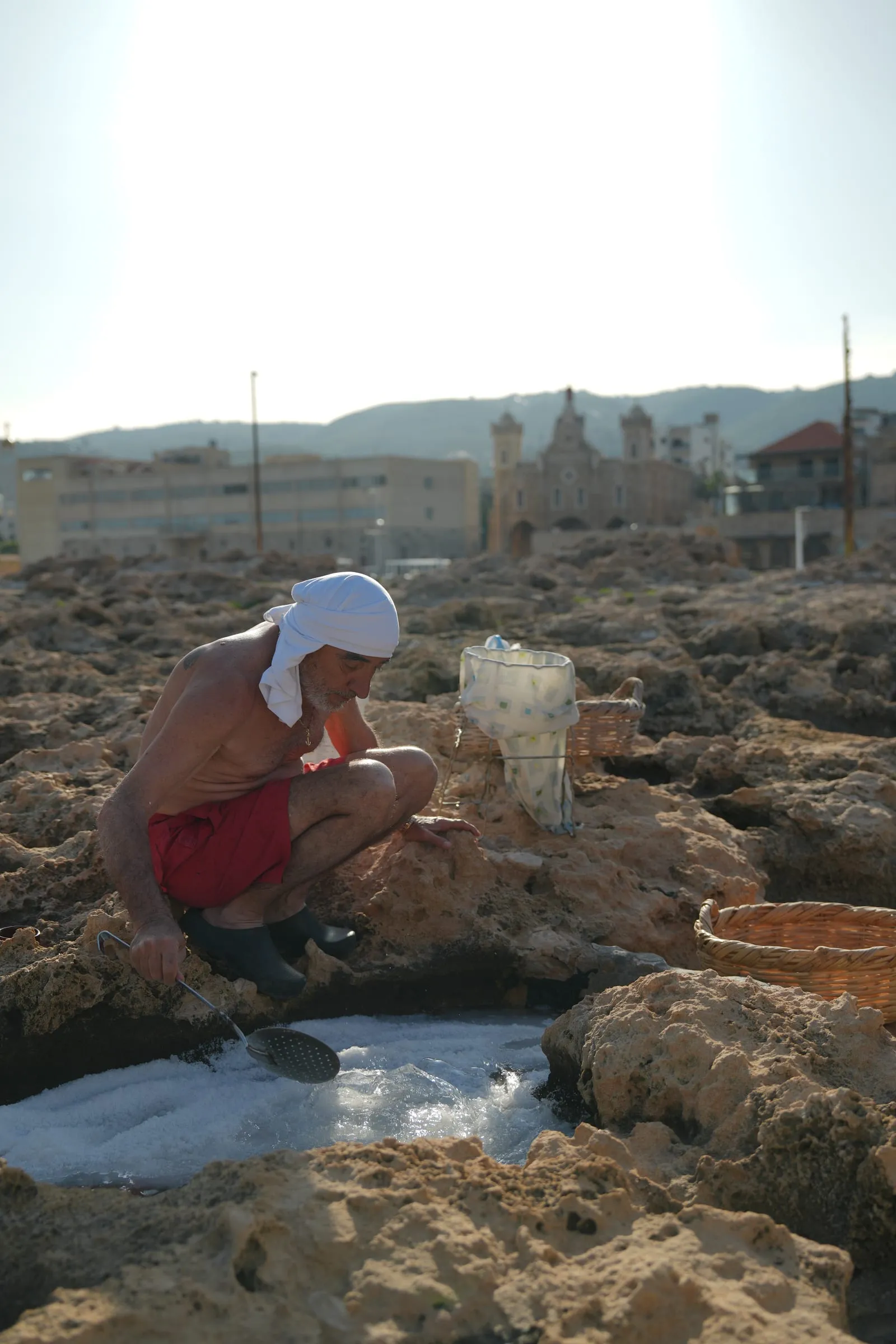 The rock pools along the Phoenician Wall with the town of Batroun behind