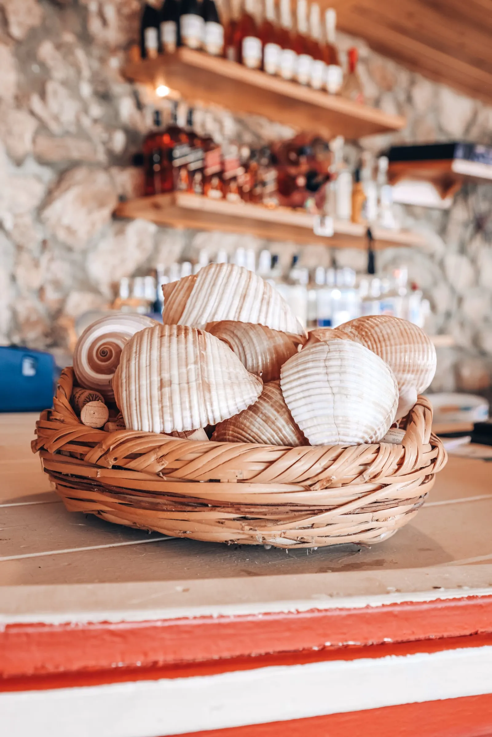 A basket of shells on the counter in front of the bar shelves at Oyster's Seafood Bar, Batroun