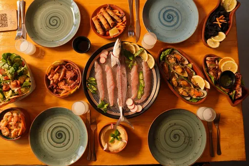 A full table at Oyster's Seafood Bar in Batroun seen from above: whole fish, mezze, salads and plates