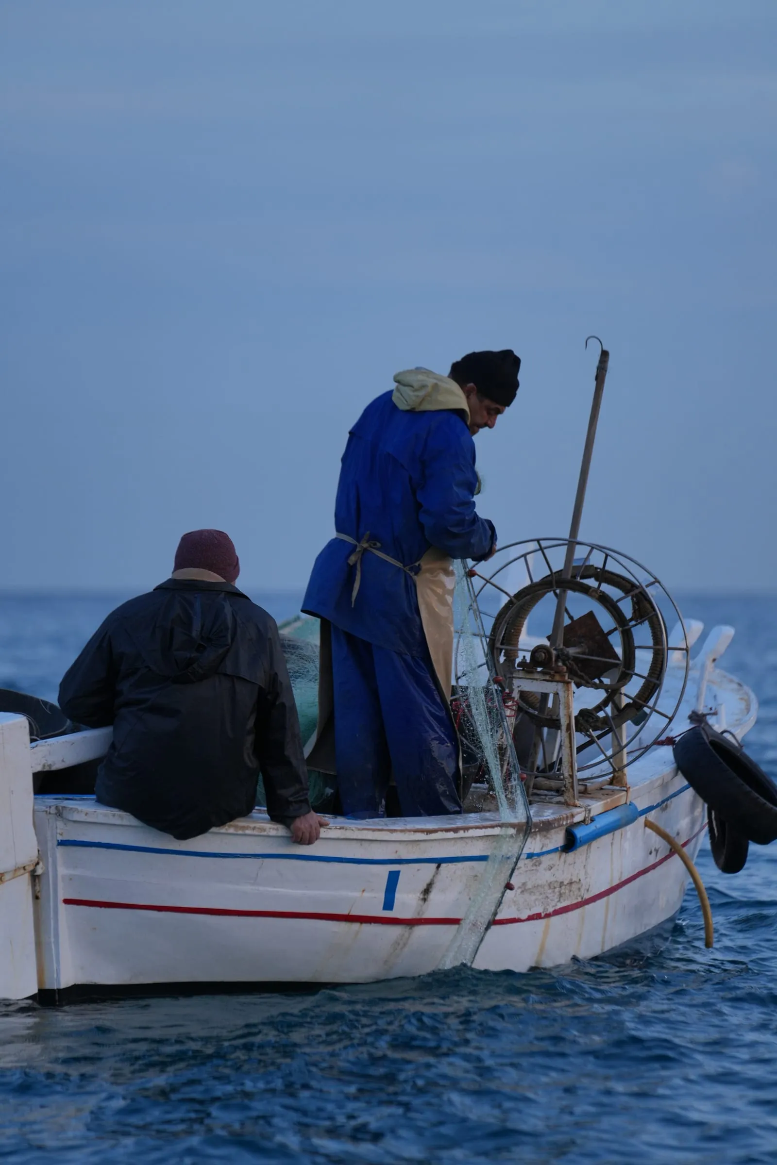 Two fishermen on a small boat at Batroun Mina, the fishermen's port
